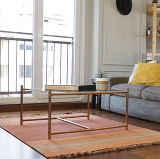 Handcrafted copper and glass coffee table with a minimalist copper frame and a clear tempered glass top.
