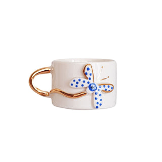 Handmade ceramic mug with a blue butterfly design, gold-plated details, and a smooth glazed finish, ideal for coffee or tea.
